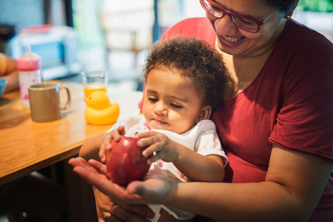 Mom letting daughter play with apple